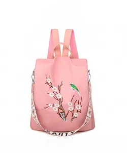 Dettaglio dello zaino rosa con ricamo floreale e uccelli e tracolla jacquard decorata
