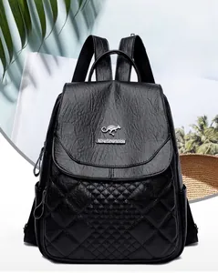 Detail of black quilted leather backpack with gold kangaroo logo and metal hardware
