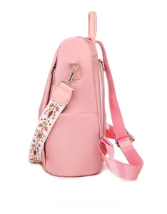 Vista laterale del versatile zaino rosa con tracolla ricamata in stile etnico