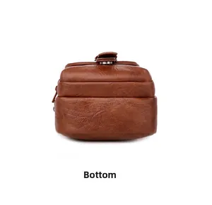 Detailed bottom view of brown textured leather crossbody bag with neat stitching