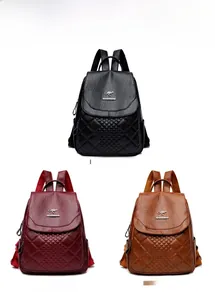 Close-up of quilted leather backpacks with metal kangaroo logo in black, red and yellow