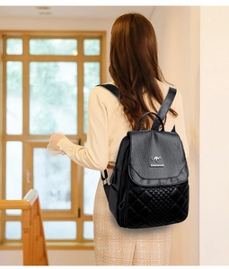 Close-up of diamond-quilted black faux leather backpack with silver kangaroo logo plaque