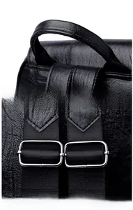 Detail view of smooth top handle and adjustable shoulder straps on black leather backpack