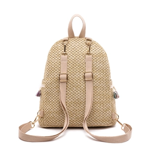 Straw woven backpack with adjustable canvas straps and colorful tassels on white background