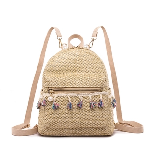 Straw woven backpack with colorful tassels and pearl accents for a summer vacation look