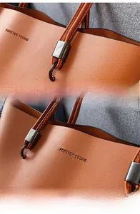 Detail of caramel faux leather tote bag with Forever Young embossing and metal ring