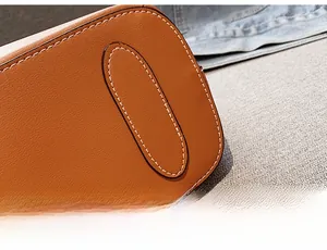 Detail of reinforced leather bag bottom with double stitching and textured finish