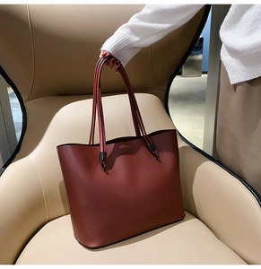 Detail of burgundy tote bag with Forever Feels embossing on a designer chair