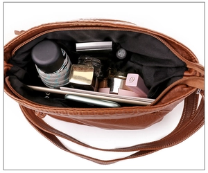 Top view of brown faux leather shoulder bag showing spacious interior with multiple items