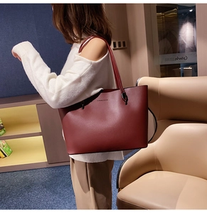 Deep red leather tote bag with Fashion Young lettering shown as a stylish shoulder bag