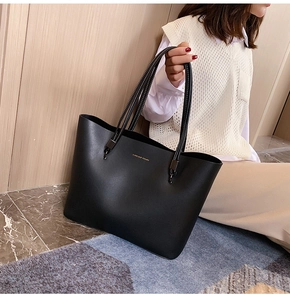 Detail of black faux leather tote with Forever Young gold lettering and metallic hardware