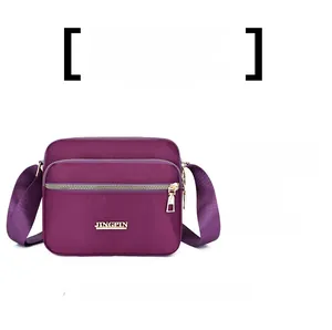 Detailed view of dark purple waterproof nylon crossbody bag with multi-zipper pockets