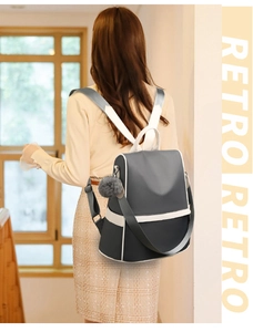 Rear view of a minimalist two-tone grey and white oxford cloth anti-theft backpack on model