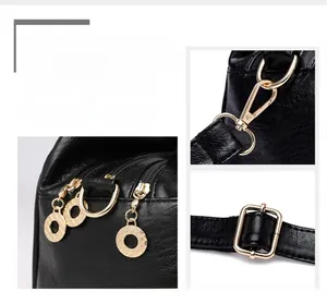 Detailed close-up of golden metal hardware on black lychee-textured faux leather bag