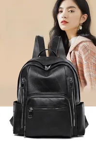 Detail of black faux leather backpack with litchi texture and front zipper pockets