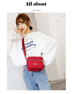 Detail of red waterproof nylon crossbody bag with zipper pocket and wide strap
