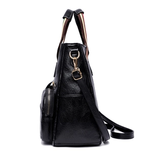 Black pebbled leather tote bag featuring golden hardware and a striped webbing strap