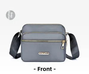Front view of grey waterproof nylon crossbody bag with golden JINGPIN logo and zipper