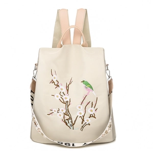 Zaino beige con ricamo floreale e spallacci rosa su uno sfondo bianco pulito