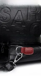 Detail der geprägten schwarzen Handtasche aus Litschileder mit silbernen Metallteilen