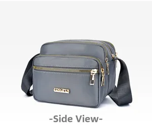 Detailed side view of dark grey waterproof nylon crossbody bag with multi-layer zippers