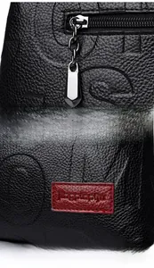 Details des Silber-Reißverschlusses und des roten Lederetiketts auf schwarzer Tasche