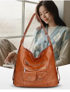 Détail d'un sac à bandoulière vintage en cuir marron avec plusieurs poches zippées