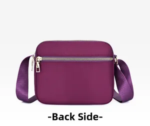 Back view of a purple nylon crossbody bag showing fine texture and wide shoulder strap