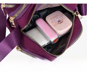 Detail of dark purple nylon crossbody bag interior showing spacious multi-layer storage