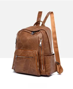 Detailed side view of brown faux leather backpack featuring zippers and textured finish