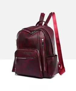 Detailed side view of wine red leather backpack showing texture and side pocket