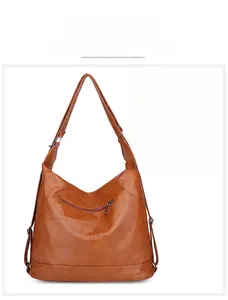 Détail de la poche arrière zippée sur un sac à main en cuir marron avec un smartphone