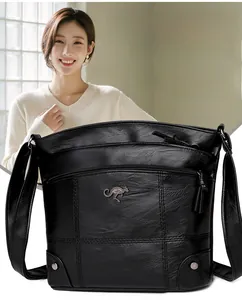 Gros plan du sac en similicuir noir texturé avec poches zippées et logo métallique