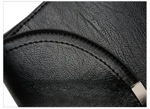 Macro shot showing high-quality stitching and lychee grain texture on a black leather bag
