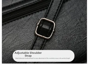 Detail of adjustable shoulder strap with metal buckle on black pebbled leather crossbody bag