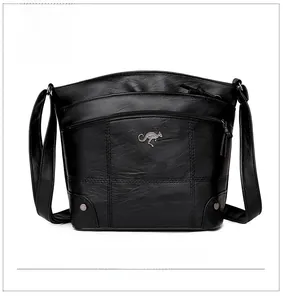 Vue détaillée du sac bandoulière en cuir noir avec logo métallique et rivets argentés