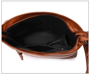 Vue intérieure du sac en cuir marron avec grand compartiment et poche zippée