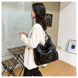 Vue détaillée du grand sac bandoulière noir avec multiples zips et texture cuir souple