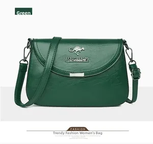 Close-up of green leather crossbody bag with silver kangaroo logo and adjustable strap