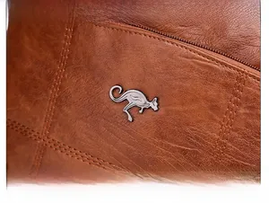Détail du sac en cuir marron avec motif litchi, logo kangourou argenté et surpiqûres