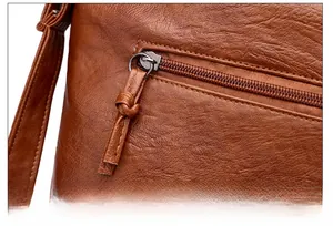 Gros plan sur le sac en cuir PU marron avec fermeture éclair en métal et pompon noué