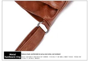 Gros plan sur les boucles en métal argenté du sac à bandoulière en cuir marron texturé