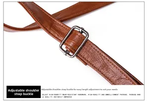Détail d'une bandoulière réglable en cuir grainé marron avec boucle en métal argenté