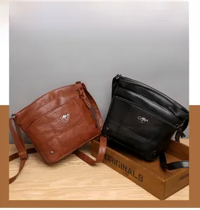 Détail de sacs à bandoulière en cuir souple avec broderies et multiples fermetures