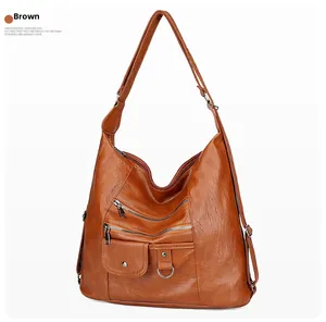 Détail d'un sac à bandoulière vintage en cuir souple marron avec plusieurs fermetures éclair