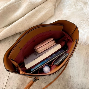 Large brown leather tote bag with spacious interior and multiple compartments for daily items