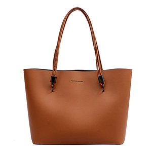 Brown leather tote bag with Forever Young print and dual handles on white background