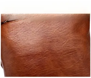 Vue macro détaillée montrant le cuir marron souple à texture litchi et le zip métallique