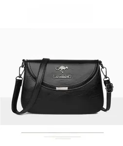 Detailed view of black faux leather crossbody bag with metal kangaroo logo and flap