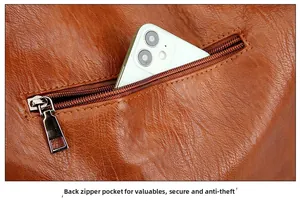 Détail d'un sac en cuir marron vintage avec une poche zippée antivol fonctionnelle au dos